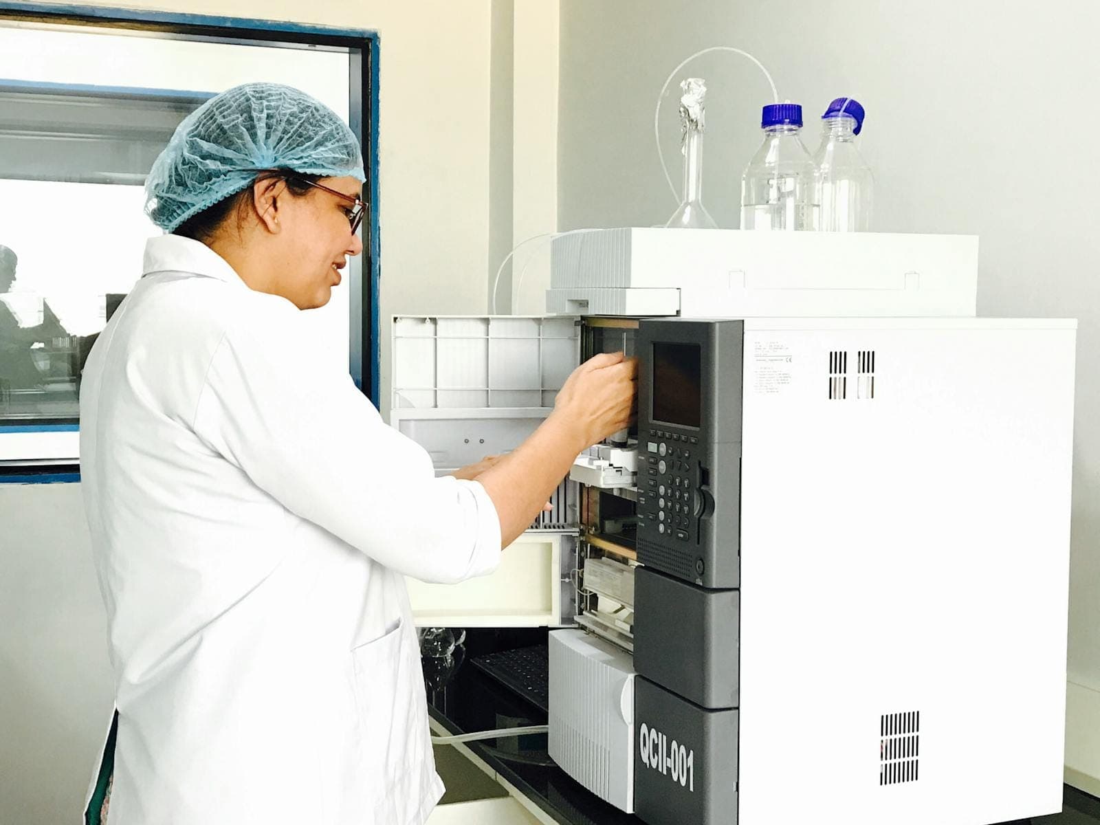 Female scientist using advanced analytical chemistry equipment in a laboratory.