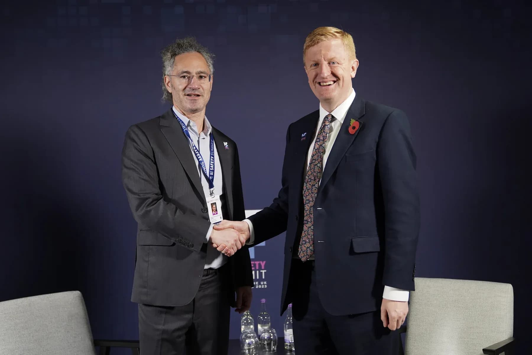 Alex Karp, CEO of Palantir, shakes hands with UK Deputy Prime Minister Oliver Dowden at the AI Safety Summit, Bletchley Park, November 2023