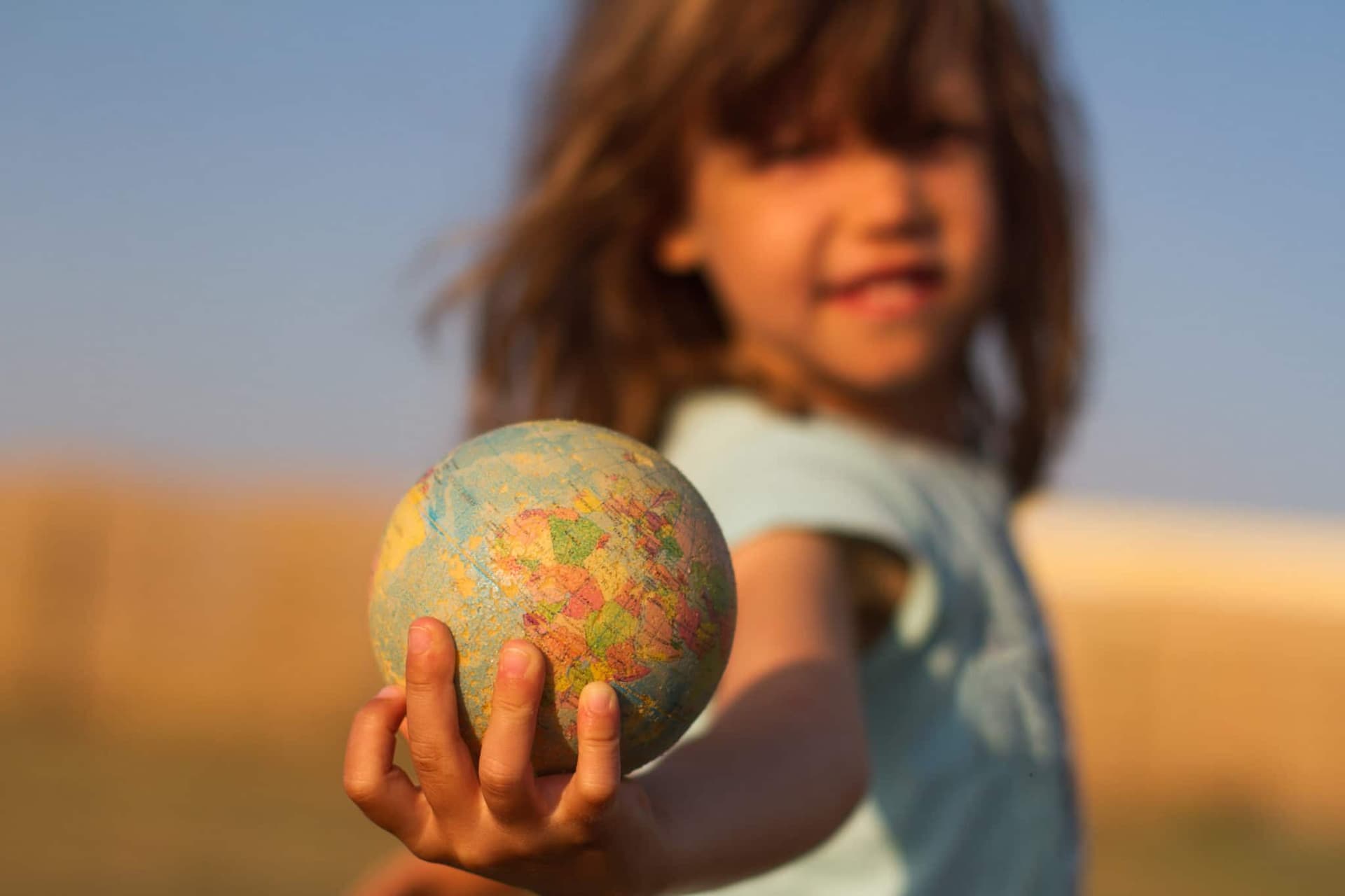 Child hand holding an earth globe