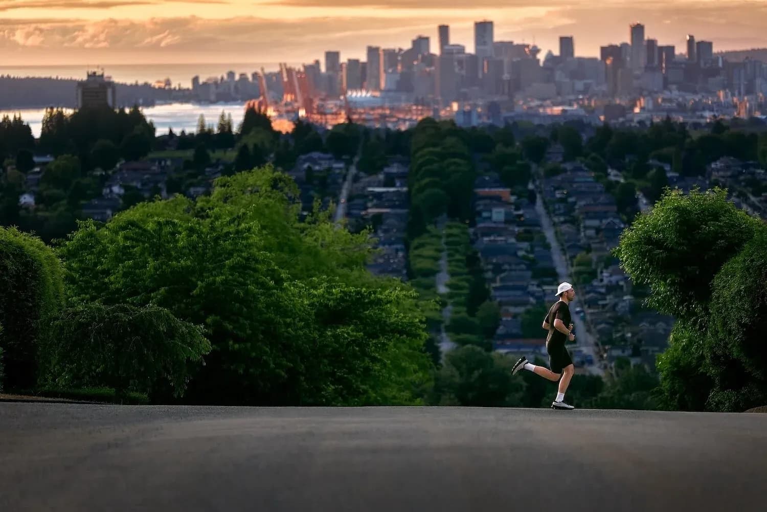 Lone runner training on a hilltop road at sunrise, illustrating endurance athlete training