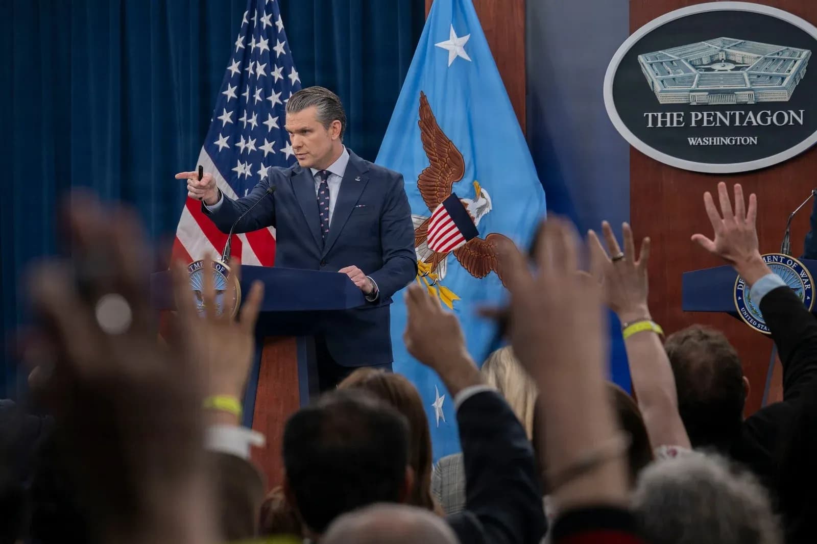 Pete Hegseth points to reporters during a Pentagon press briefing on Operation Epic Fury, March 2026. DoD photo by Staff Sgt. Milton Hamilton, US Air Force, via DVIDS.