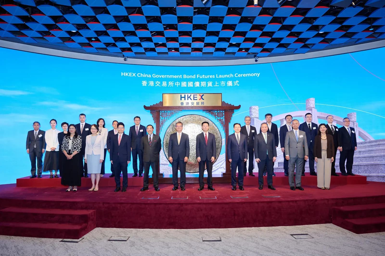 Officials stand in a row at the HKEX Connect Hall ceremony marking the start of trading in China Government Bond futures, with a ceremonial gong at the centre.