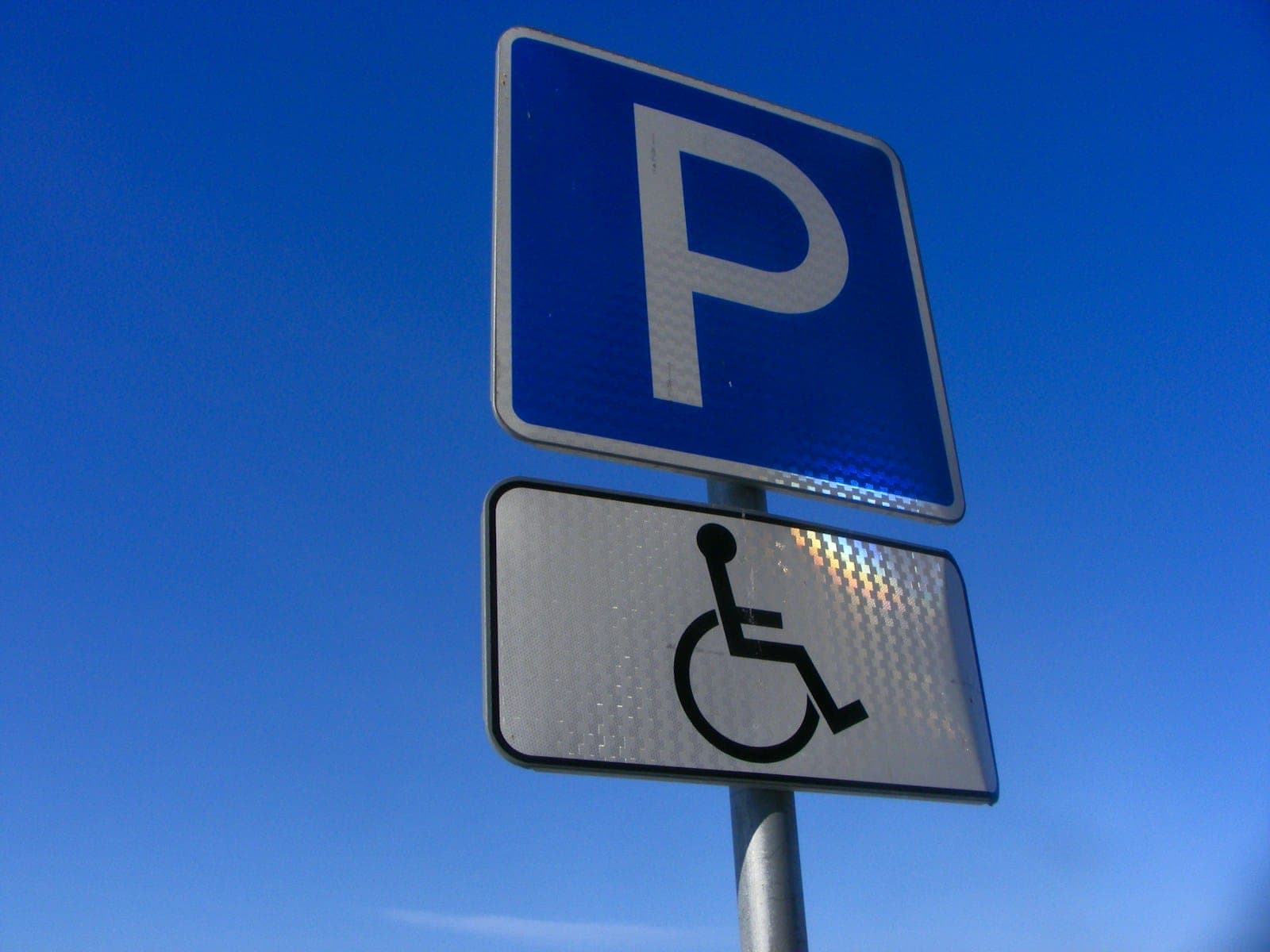 a blue parking sign with a handicap symbol on it