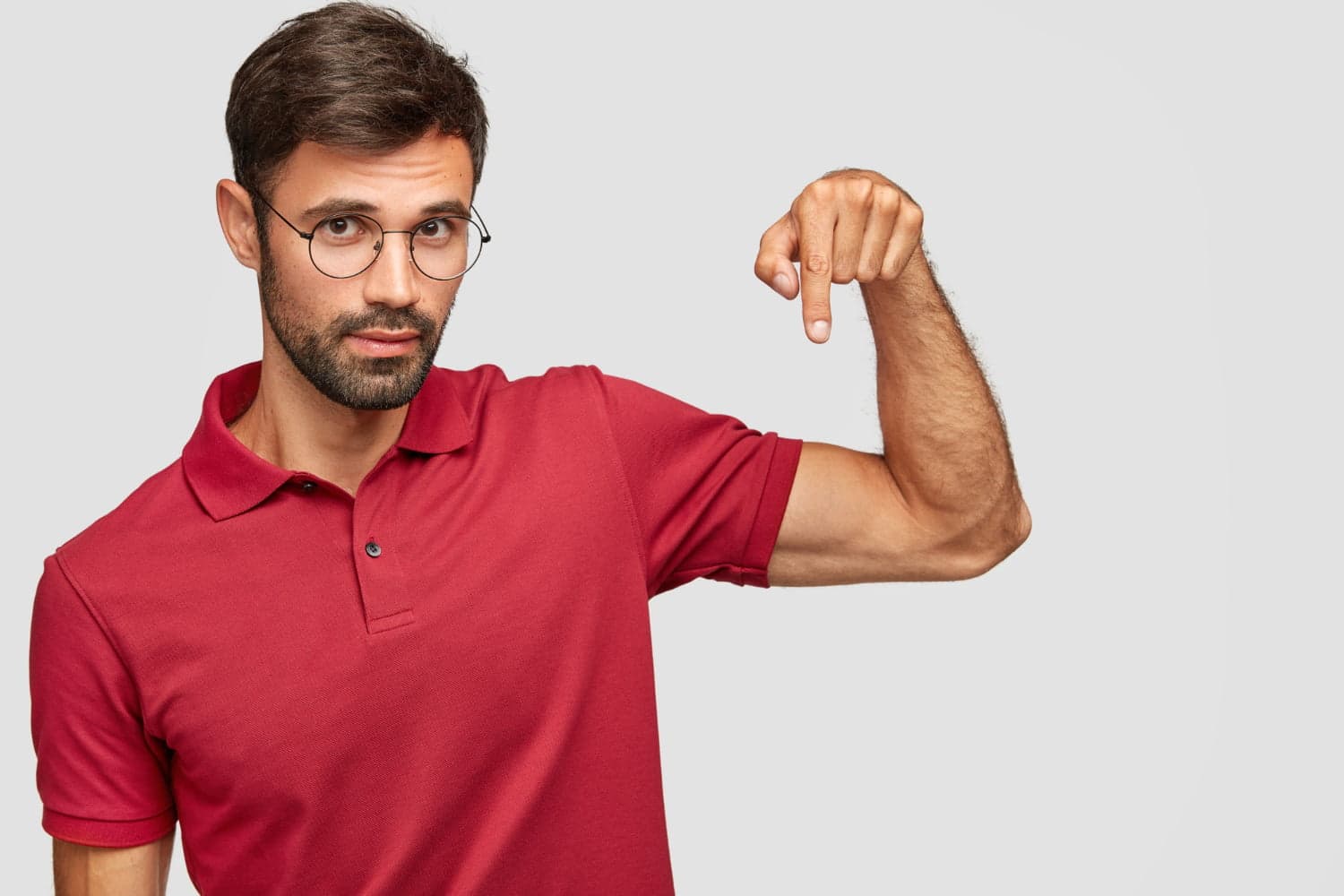 confident-unshaven-male-model-eyewear-red-t-shirt-points-down