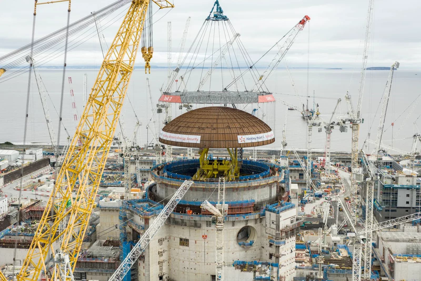 The world's largest crane Big Carl lifts the dome onto the second reactor building at Hinkley Point C in Somerset