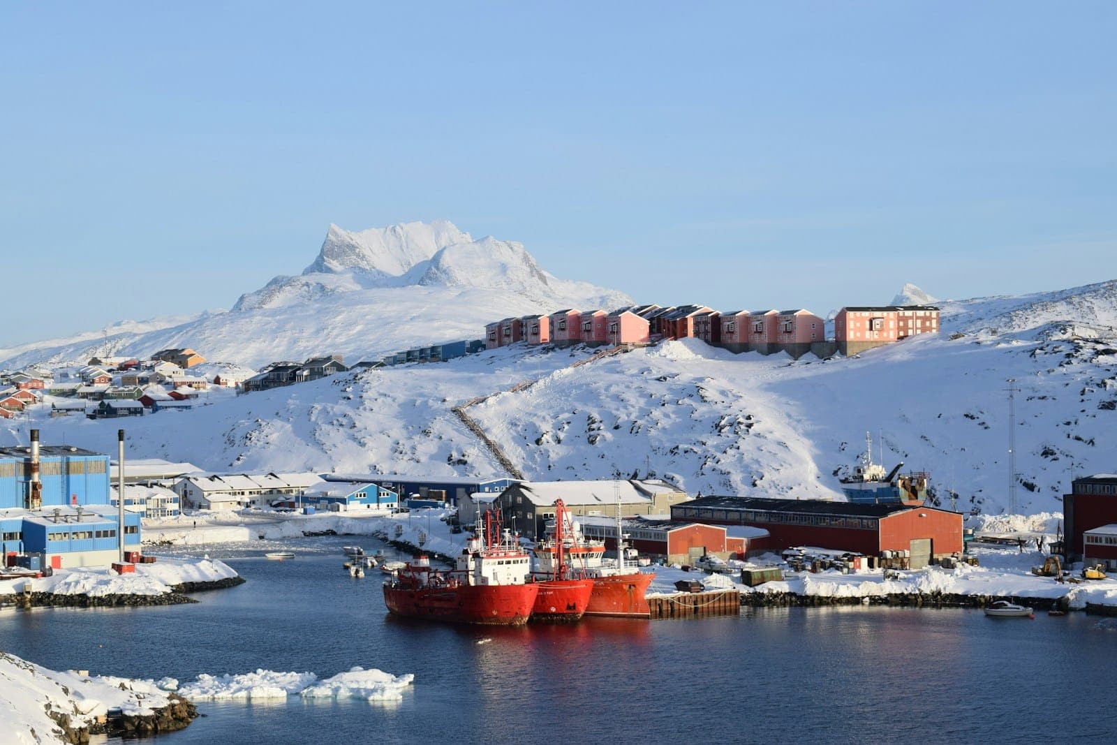 red and white ship on sea near mountain during daytime