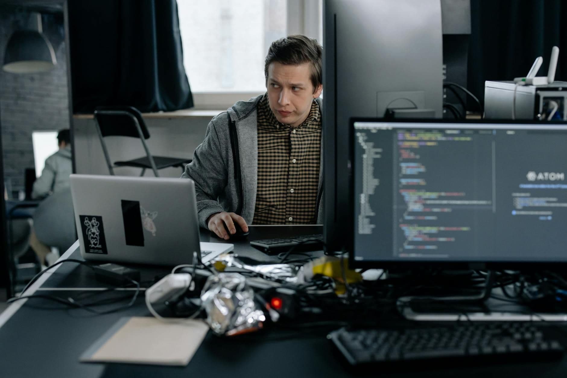 A programmer in a modern office working on computer code, showcasing a focused work environment.