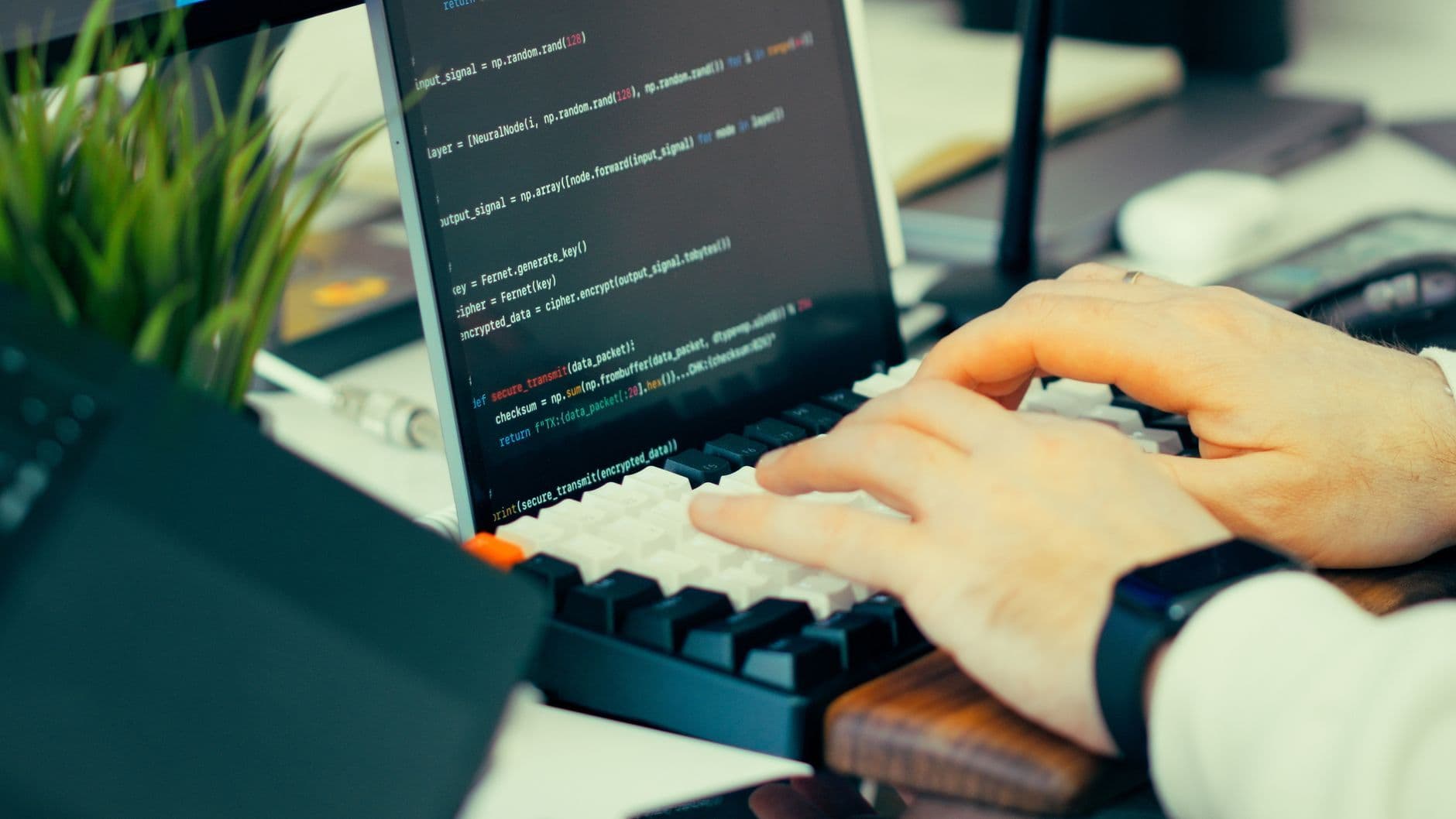 A developer's hands typing code on a laptop keyboard
