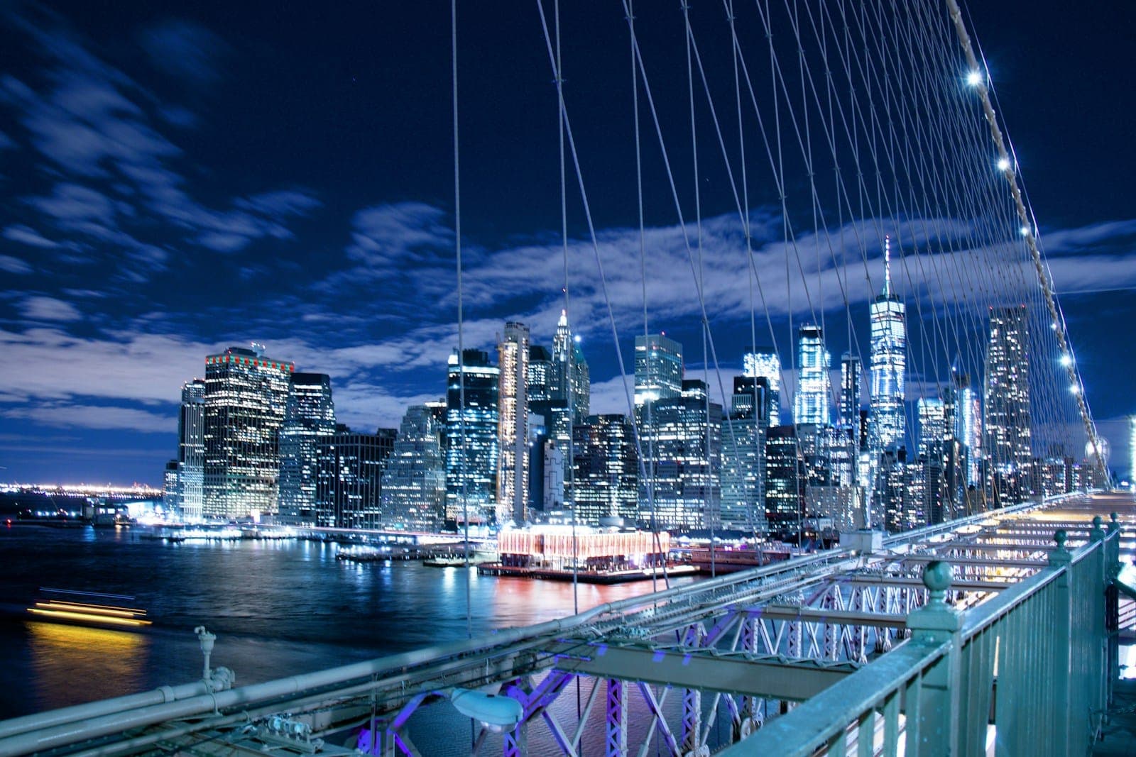 panoramic photo of buildings through bridge cables