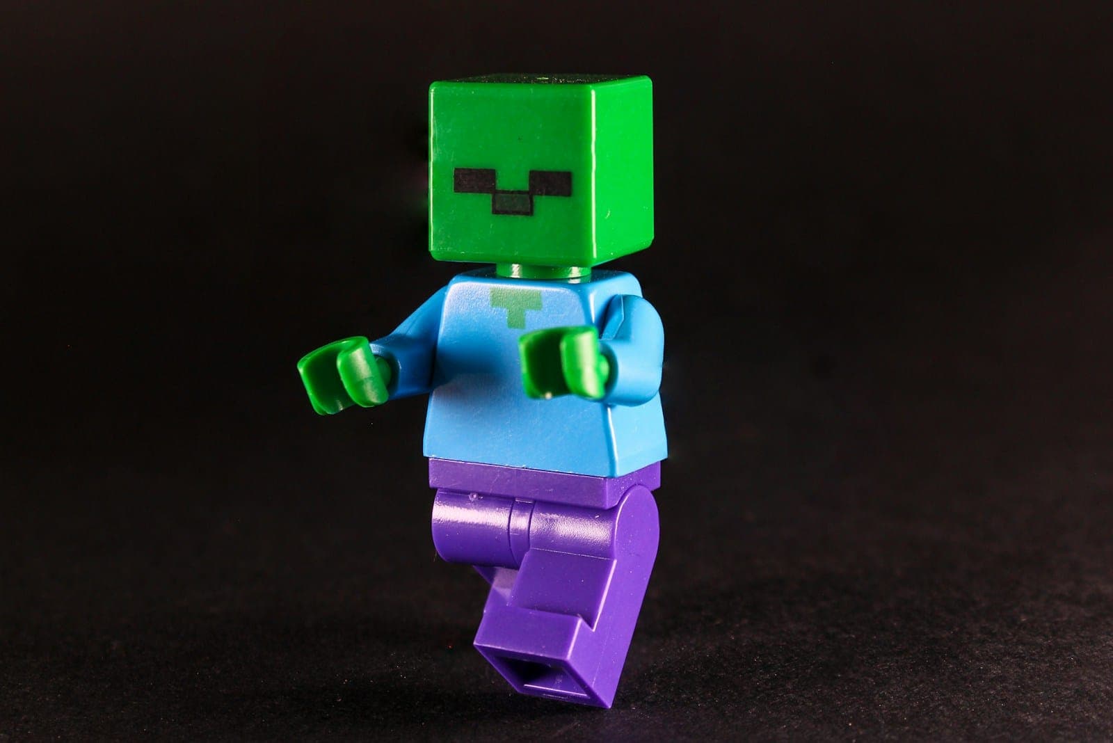 A green lego zombie figure on a dark background.