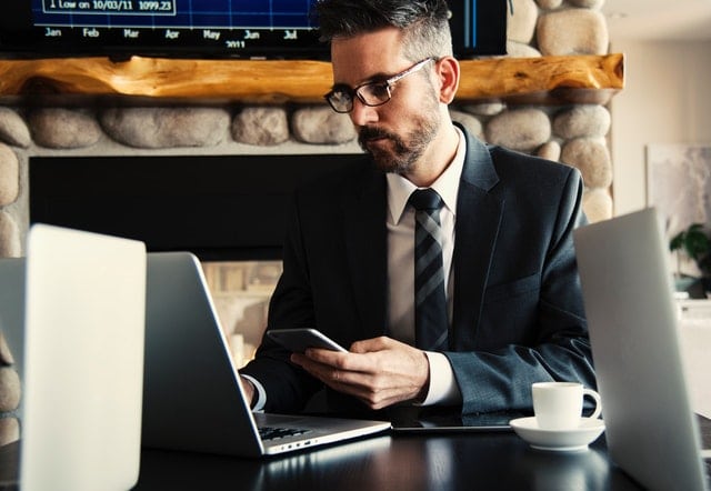 man sitting at desk while working from his laptop