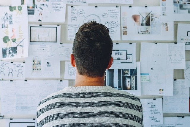 Man assessing ideas board for lead generation strategies