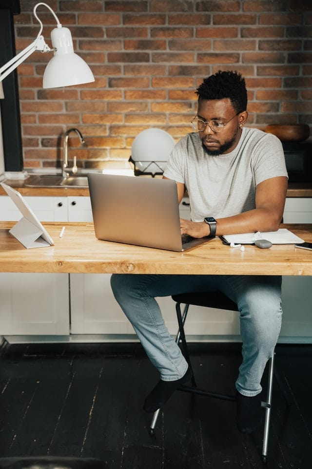 Career in marketing: Man at home sitting at a desk working on his laptop