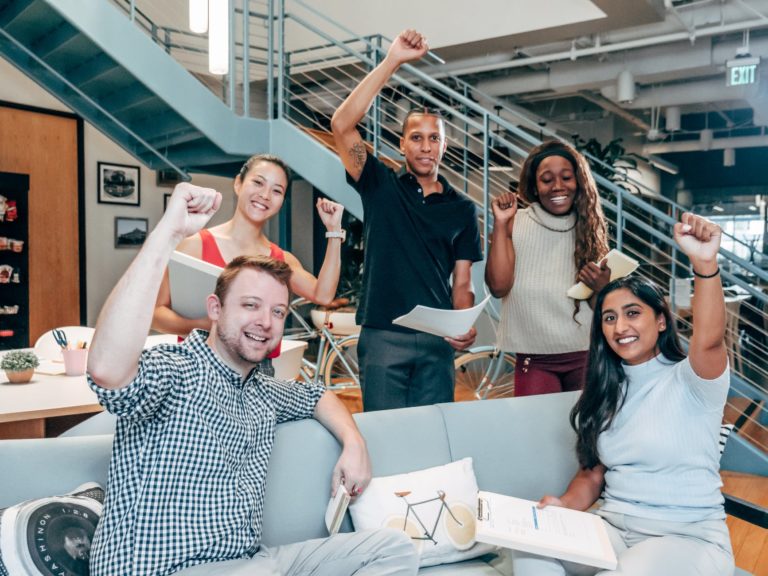 The four-day working week – a worthwhile experiment for employers? 1 group of people putting up their fist