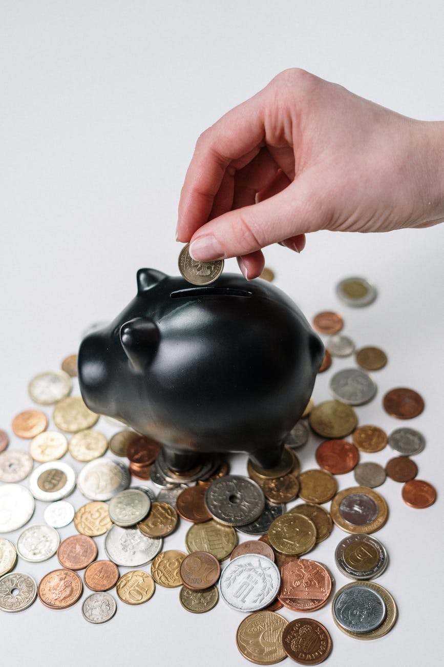 Things To Spend Money On To Enhance A Business 1 person putting coin in a piggy bank