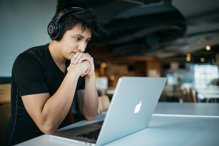 Stress Awareness Month: the importance of stress management at every stage of business 1 man wearing headphones while sitting on chair in front of MacBook