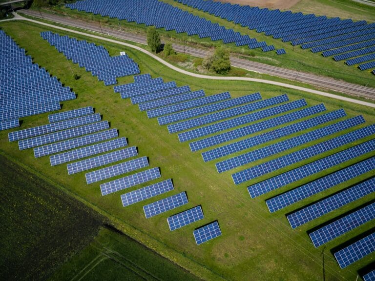 Solar Innovator Naked Energy Partners with Leading Lithuanian Distributor Axioma Service 3 aerial photography of grass field with blue solar panels