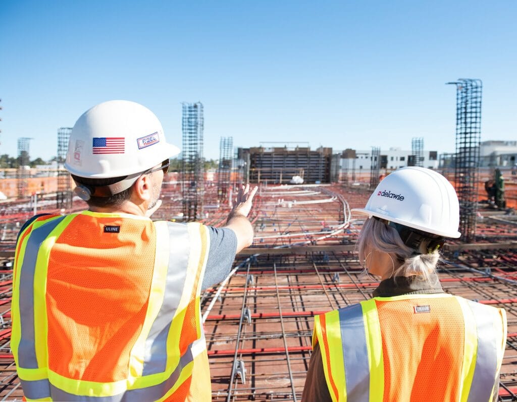 Reshaping Development to Empower Women Leaders and Entrepreneurs Globally 2 man in white hard hat standing on brown wooden dock during daytime