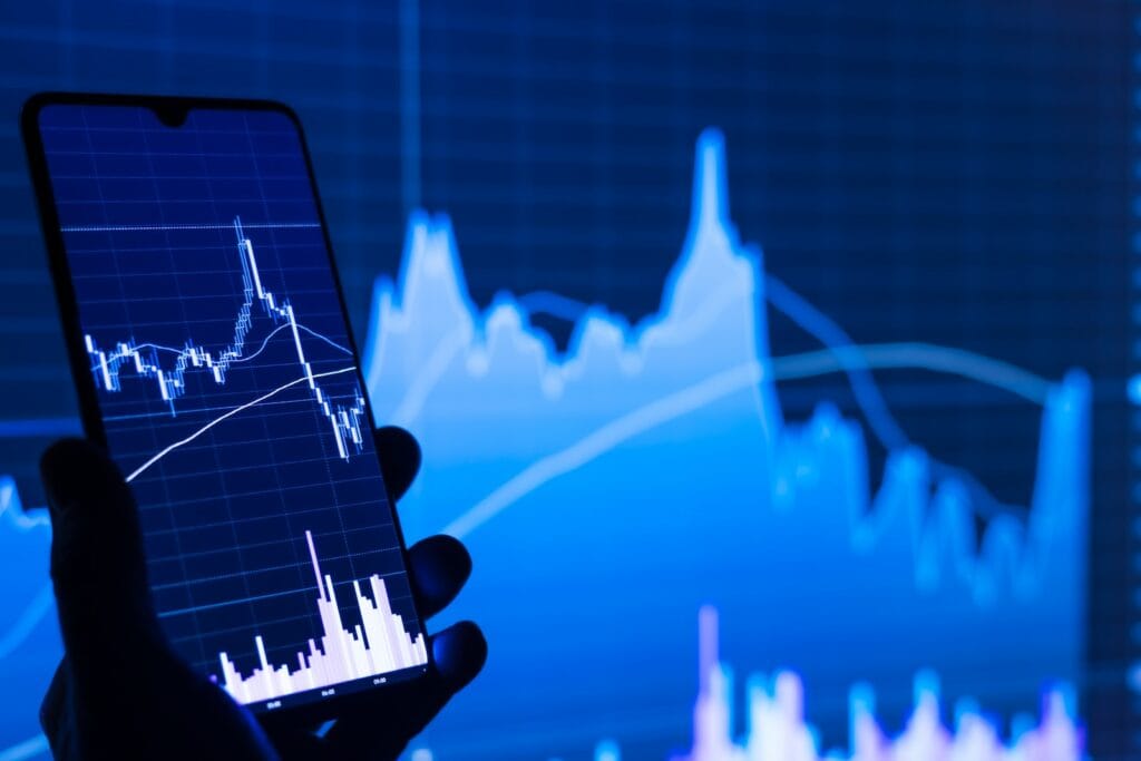 AI's Influence on Stock Market Investments 4 a person holding a cell phone in front of a stock chart