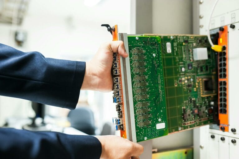 India Seeks Cost-Effective AI Model Expansion as GPU Scarcity Spurs CPU-Based Solutions 1 A technician inserts a circuit board into a server rack, illustrating technology and connectivity.