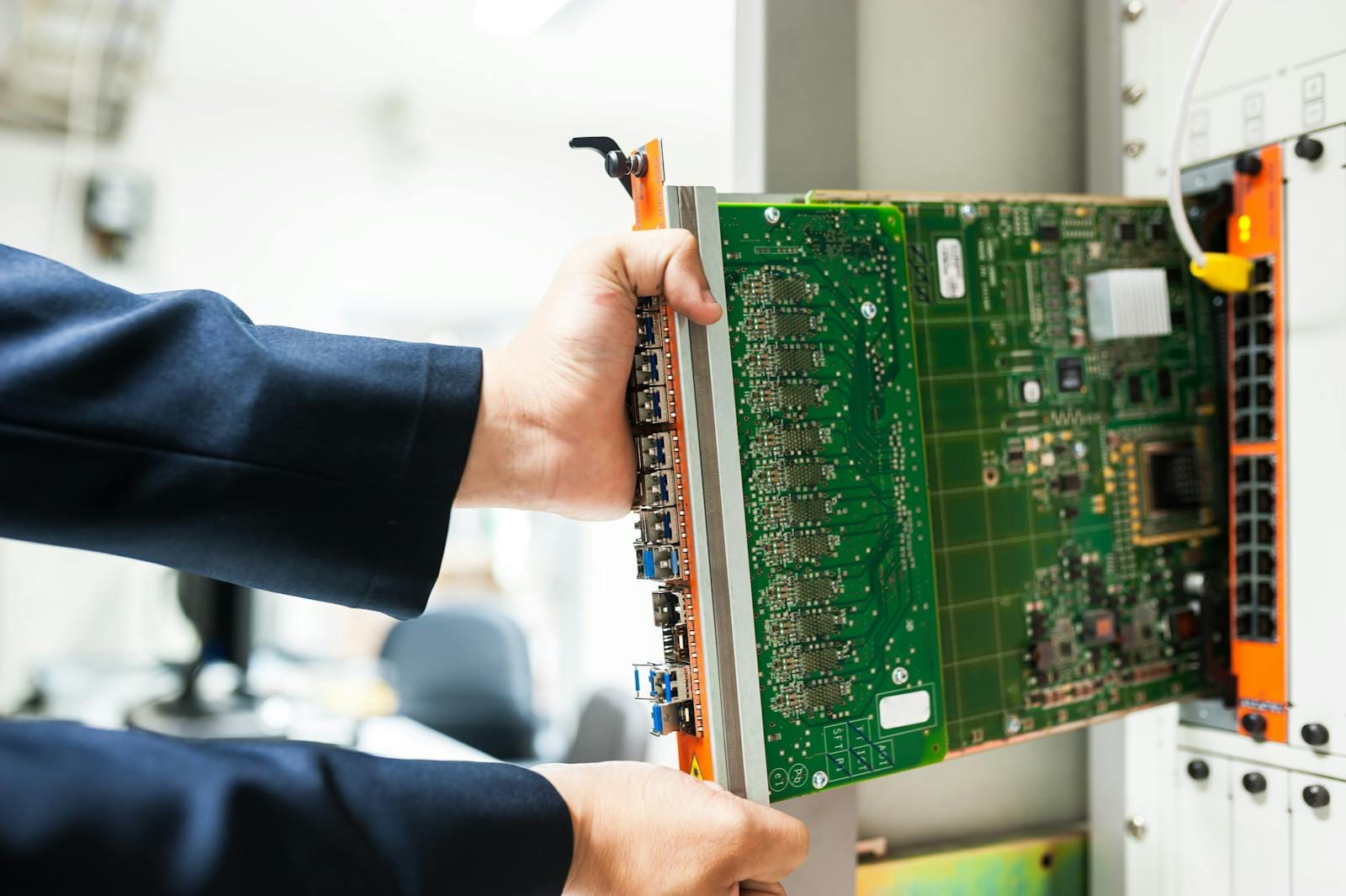 India Seeks Cost-Effective AI Model Expansion as GPU Scarcity Spurs CPU-Based Solutions 1 A technician inserts a circuit board into a server rack, illustrating technology and connectivity.