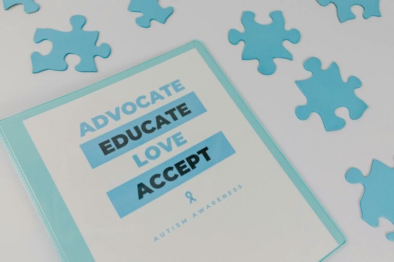 Autism Support Surges as Detection Hits 1 in 31 Children Nationwide 10 Binder with advocacy message amidst puzzle pieces for autism awareness.