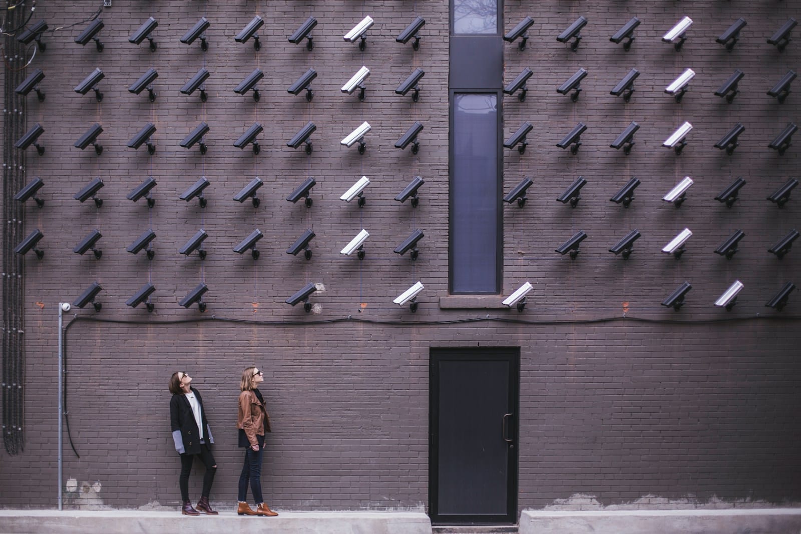 Firms Step Up Software Security: What JFrog and TL Consulting Are Doing Differently 1 two women facing security camera above mounted on structure