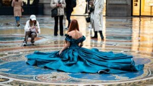Woman in gown poses on a patterned floor.